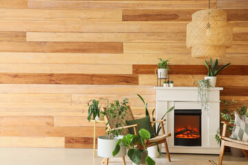 Stylish fireplace and armchairs near wooden wall