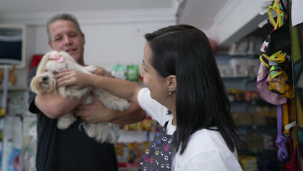 Happy Client Pays for Grooming Procedure, Contactless Payment at Pet Shop with Small Dog in Hand