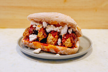 presentation of a plate with a meatball sandwich.