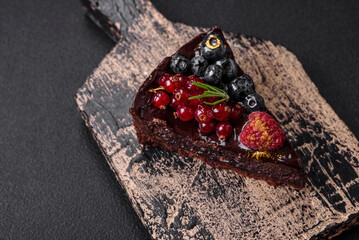 Delicious sweet chocolate brownie cake with blueberries, currants and raspberries