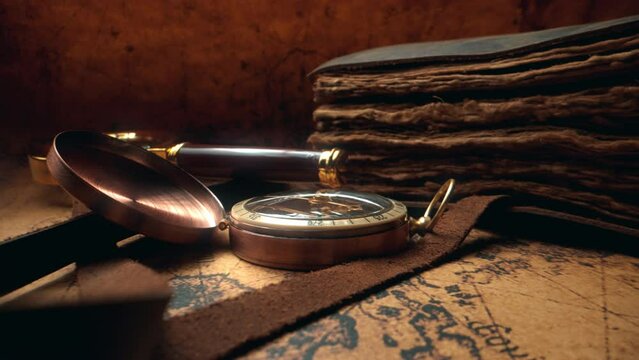 Compass and magnifier on a old vintage world map with countries and continents. Retro style aged book. Concept of geography or global history and cartography. Wars of conquest and navigation