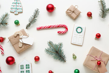 Christmas tree branches with balls, gift boxes and candy cane on white background