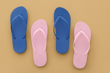 Colorful pairs of flip flops on beige background