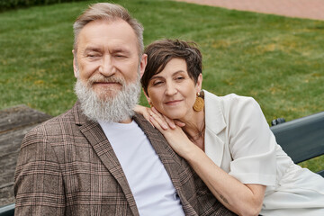senior couple in love, elderly woman leaning on shoulder of man, husband and wife, outdoors, romance