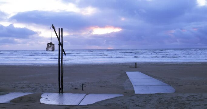 Lantern sways in the wind on the shores of the North Sea in the evening.