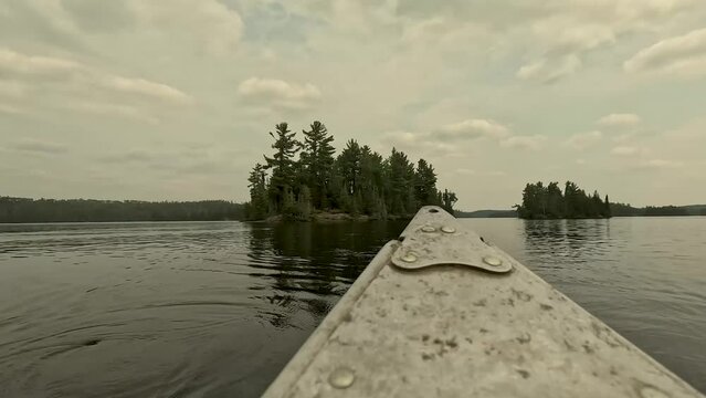 time lapse of a canoe leaving a small island as it rows away