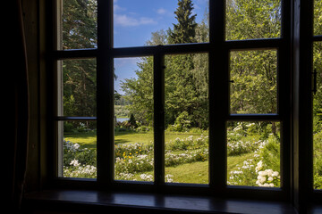 view through an open glass door on a sunny summer russian landscape