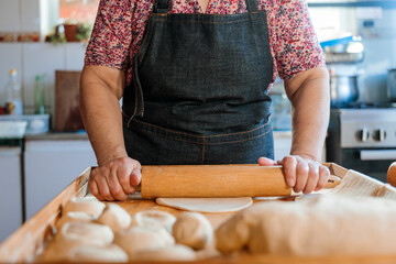 Unrecognizable Hispanic Woman Kneading Dough with Hands and Rolling Pin in Her Countryside Kitchen