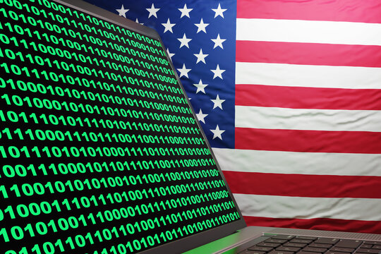 Silver laptop showing computer binary code with national flag of the USA as background. Illustration of the concept of American computer fraud and abuse act