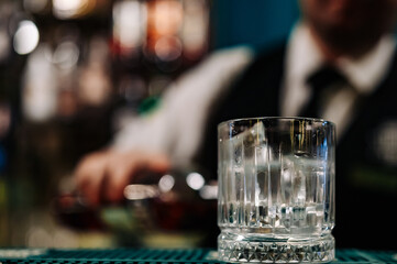 man bartender hand making negroni cocktail. Negroni classic cocktail and gin short drink with sweet vermouth, red bitter liqueur