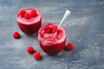 Traditionelle Himbeer Mousse mit Joghurt und Früchten serviert als Nahaufnahme in einem...