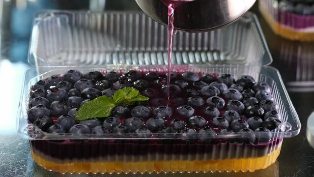 cooking jelly cakes with berries at home pour layers of delicious dessert beat in a blender. smooth with a tablespoon in a plastic container delicious dessert pour blueberry jelly mousse