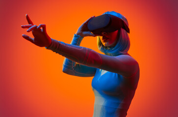Obraz premium Woman in VR headset interacting with virtual world