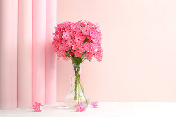 Home interior with decor elements, beautiful phlox flowers in a vase on a light background, abstract flower composition, still life with place for text, floral card for birthday, wedding, 