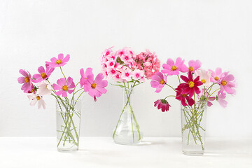 Abstract floral composition.Beautiful chamomile flowers and phloxes in a vase on a light background, Home interior with decor elements, still life with place for text, floral card for birthday,