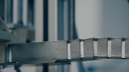 Obraz premium Many white plastic bottle caps falling from conveyor belt. Factory - production line - close up. Automated industrial equipment. Manufacturing, recycling, industry, technology equipment concept