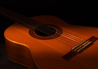 Acoustic guitar with dark background and thin light stream, old fashioned way casette recording