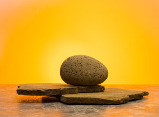 minimalist composition with stones on yellow background for product presentation background podium