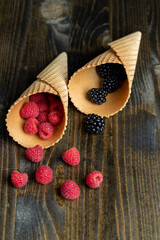 Ripe red raspberries in a crispy waffle cone