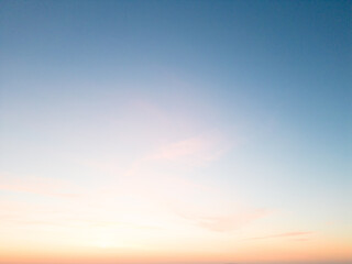 Fototapeta premium Amidst a serene backdrop, the dawn breaks, painting the horizon in myriad shades of pink. A drone captures this breathtaking ballet of nature from a bird's-eye perspective, 