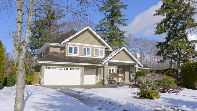 Establishing shot of two story stucco luxury house with big tree and nice landscape at winter in Vancouver, Canada, North America. Day time on January 2023. ProRes 422 HQ.