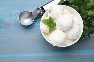 Delicious vanilla ice cream, mint and scoop on light blue wooden table, flat lay. Space for text