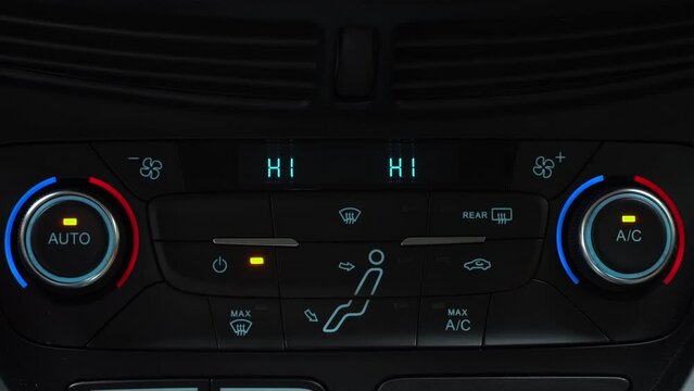 Finger presses button for turning off maximum airflow on the multimedia panel of car, two-phase climate control in the car