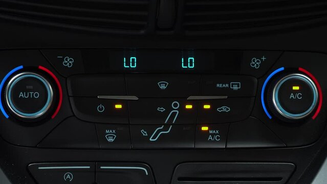 Finger presses button for turning on maximum ac airflow on the multimedia panel of car, two-phase climate control in the car