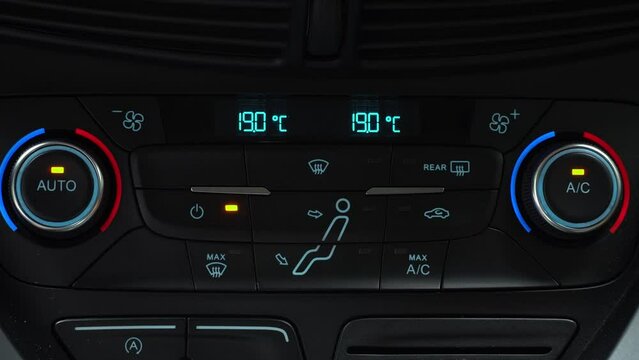 Finger presses button for turning off maximum ac airflow on the multimedia panel of car, two-phase climate control in the car