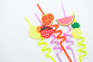 close up colorful fruit drinking staws on white background
