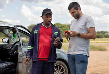 two drivers exchanging insurance information after an accident pulled on the side of the highway