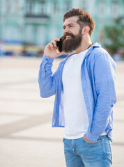 glad guy speak on smartphone outdoor. guy speak on smartphone outside.