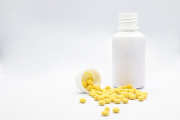 Medicine container with yellow pills for hospitals and sick people on white background