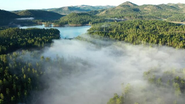 High aerial of a lake nestled into the foot of the mountains in South Dakota
