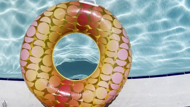 Colorful floating round kids float in a pool sparkling water