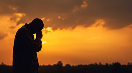 Silhouette of man praying on sunset finding solace in faith religion concept