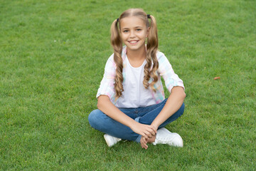 teen girl sitting outdoor in her childhood lifestyle relax on summer lawn grass