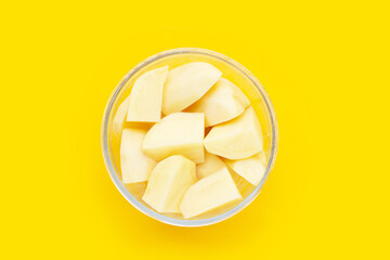Fototapeta na wymiar Raw peeled potatoes on yellow background