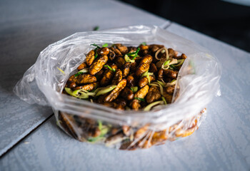 Steamed silk chrysalis with lemongrass and kaffir lime leaves is a snack food in the Northeast of Thailand.