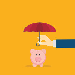 Hand holding small umbrella over piggy bank