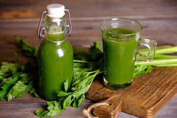 Obraz na płótnie Canvas celery juice in clear glasses and bottles. Celery is a leaf vegetable and medicinal plant commonly used as a cooking spice. This juice has health benefits, diet drinks and health drinks. Celery.