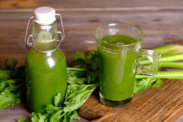 celery juice in clear glasses and bottles. Celery is a leaf vegetable and medicinal plant commonly used as a cooking spice. This juice has health benefits, diet drinks and health drinks. Celery.