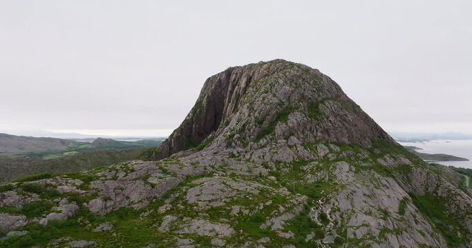 Drone flight orbit Torghatten with dark mystical hole through mountain