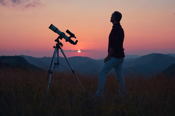 Astronomer looking at the skies with a telescope.