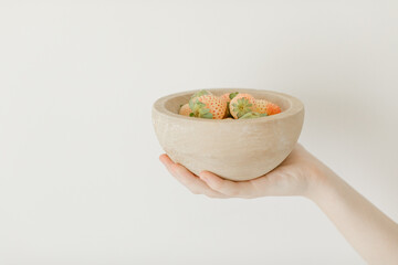 pink strawberries in wooden bowl