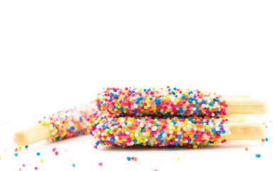  bread sticks with rainbow sugar on white background