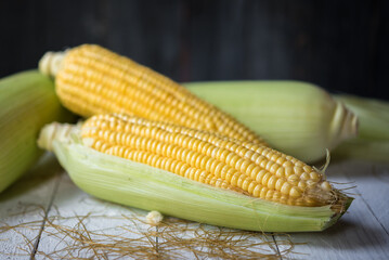 Fresh corn on rustic white wooden table, closeup