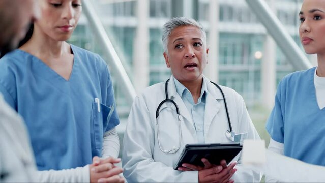 Doctors, talking and team discussion in a hospital for collaboration, concern or planning. Medical staff, health care and group of people with tech for management, consulting or communication at work