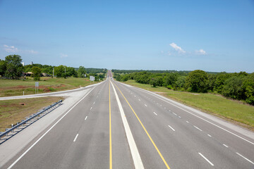 Highway in the American countryside, driveway with lane, sign, nature, blue sky background.