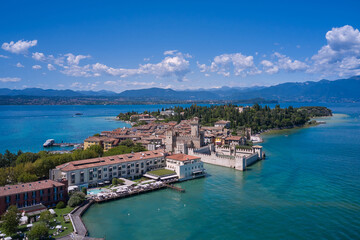 Fototapeta na wymiar Aerial view to the town of Sirmione, popular travel destination on Lake Garda in Italy. View of the city of Sirmione. Panoramic view of Lake Garda. Sirmione, an ancient village on southern Garda Lake